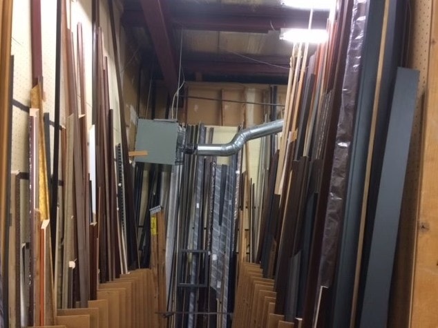 Rows of frame moulding inventory stacked in the shop