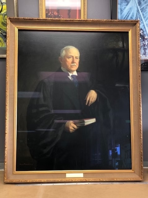 Framed formal portrait of a judge in academic robes