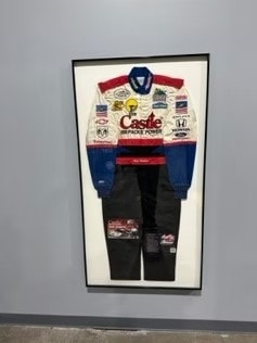 Framed racing suit display with Castle Brake Power sponsorship livery
